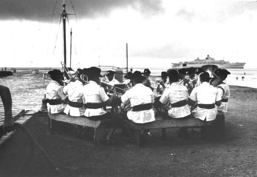 Photograph depicting a band playing at a port