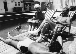 Photograph depicting passengers sitting by ORIANA's pool