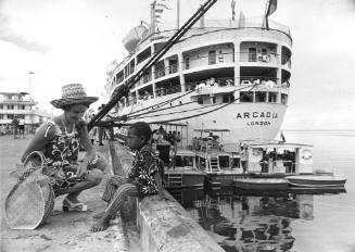 A passenger from the P&O liner ARCADIA chats with a little Fijian boy before boarding one of the cruises