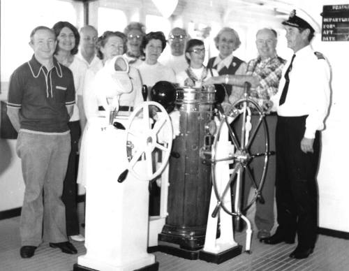 Photograph depicting a group of people on a ship's bridge