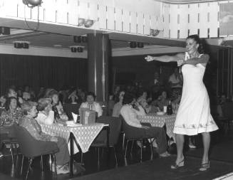 Photograph depicting a woman walking on a catwalk