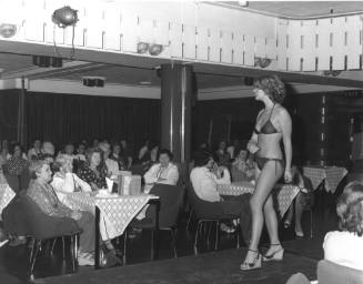 Photograph depicting a woman walking on a catwalk