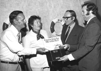 Photograph depicting two men presenting a P&O prize to a couple