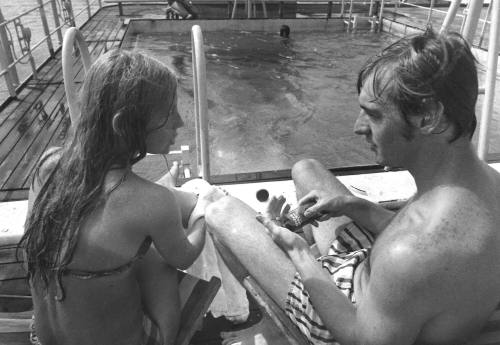 Photograph depicting a couple sitting by the ship's pool