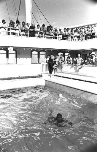 Photograph depicting a man swimming in the ship's pool