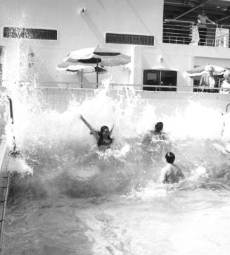 Photograph depicting three people in the ship's pool