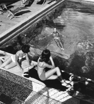 Photograph depicting a man floating in the ship's pool