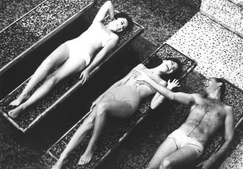 Photograph depicting three people sunbathing