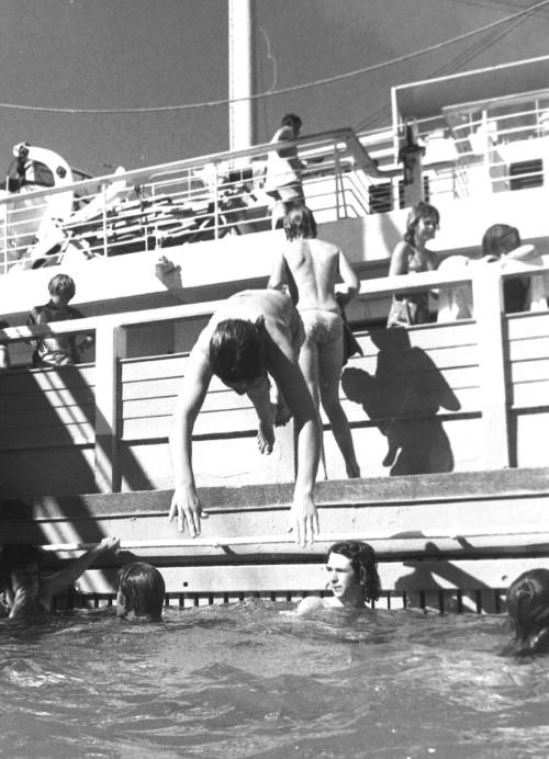 Photograph depicting a person diving into the ship's pool