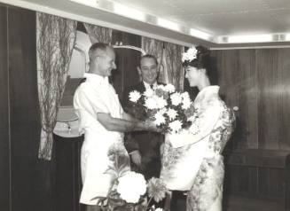 Photograph depicting a man giving flowers to a woman