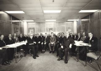 Group of men sitting in a room posing for the camera