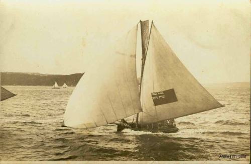 Postcard featuring a photograph of a skiff sailing on the water, with an Australian flag visible on the raised sail