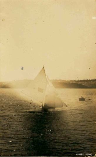 Postcard featuring a black and white photograph of skiff sailing in the water,