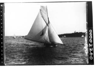 Yacht on Sydney Harbour, possibly DEFIANCE or KERIKI, displaying a crescent moon emblem on the mainsail