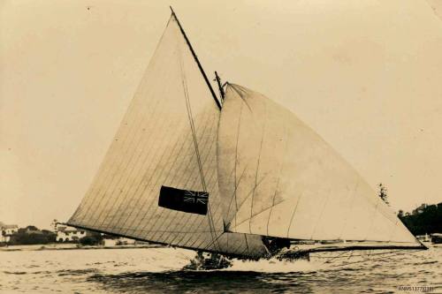 Skiff sailing in the water, with a flag on the raised sail