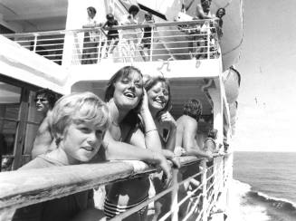 Photograph depicting people standing by a ship's rails