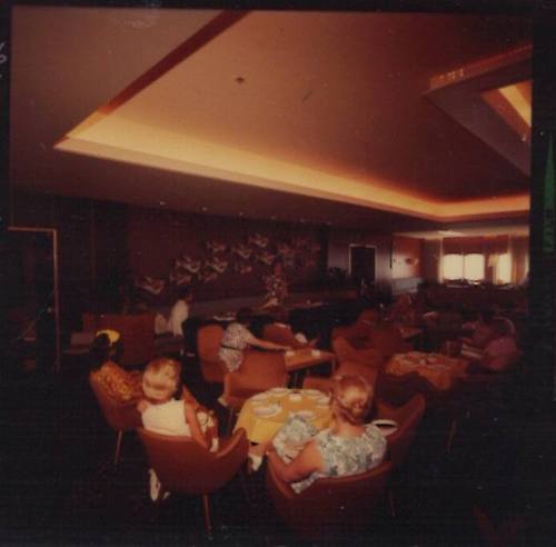 Negative depicting a group of women sitting at a ship's saloon