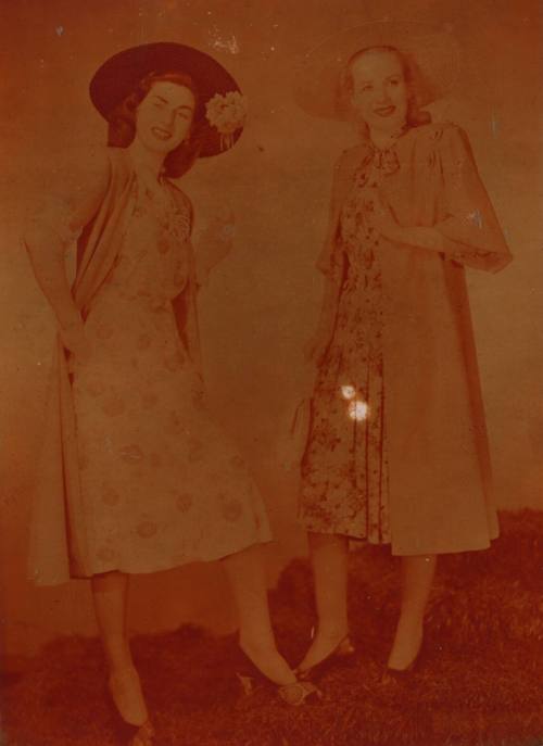 Photograph depicting two women in summer dresses and hats