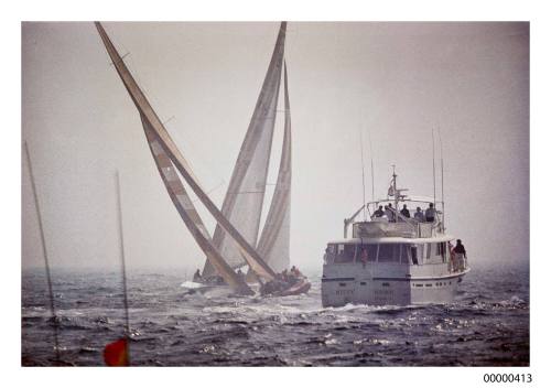 The committee boat tries to get a closer look at AUSTRALIA II as she surges ahead of LIBERTY