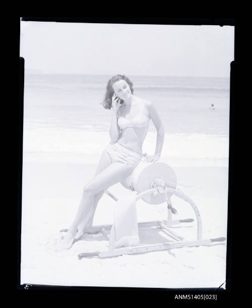 Negative depicting a woman sitting on a surf reel