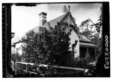 Single storey house, viewed from behind the fence.