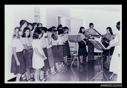 Scene in room with rows of young girls girls playing instruments