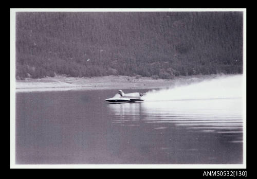 Water view depicted Blowering Dam with speed boat METEOR under power