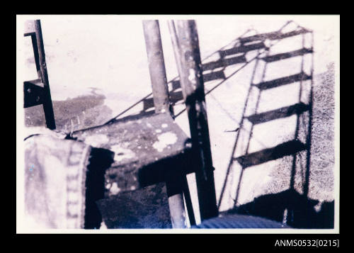 Shadow of a metal ladder with rungs against a wall