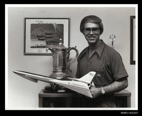 Lee Taylor standing beside a trophy