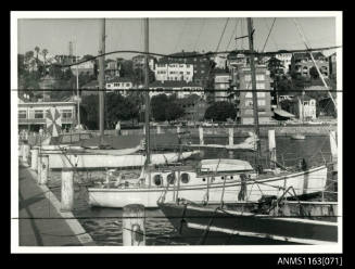 The four sailing boats moored bow or stern first to wharf