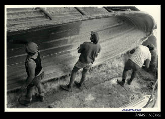 The view of three men sealing the surface of fibre glass matting