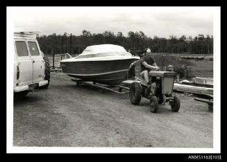 The completed fibre glass power boat on small factory trailer being towed by a Howard Tractor