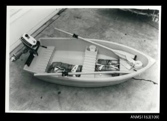 Small dinghy with oars and fitted with an Evinrude outboard engine