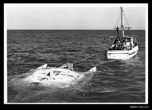 Sailing trimaran, dismasted and almost submerged