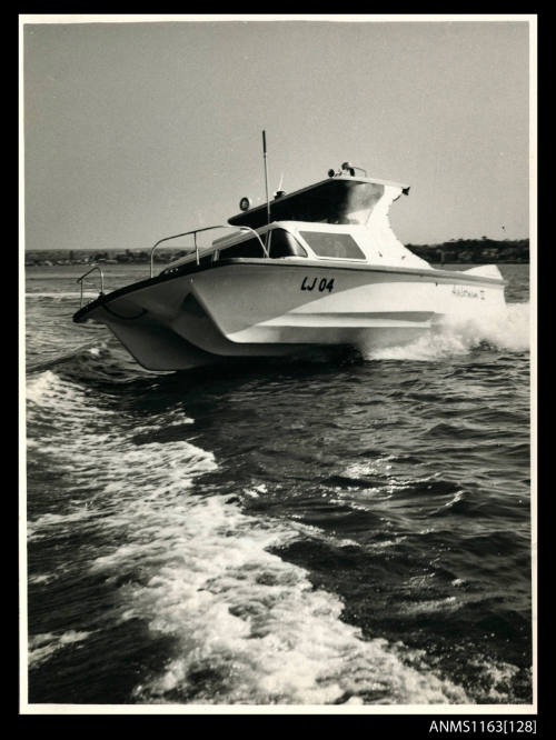 The AUSTRALIA II LJ04  triple hull half cabin power boat at speed completing a turn and heeling to starboard