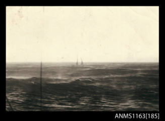 The distant view of a ship, starboard view, across stormy seas