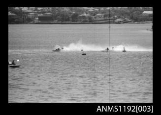 Two power boats at speed passing a marker buoy