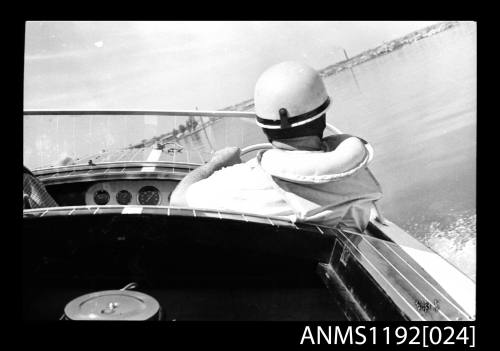 George Kilpatrick at the wheel of the power boat MELODEE