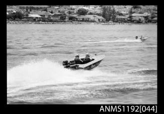 Power boat NAUTI LASS with twin outboard engines at speed