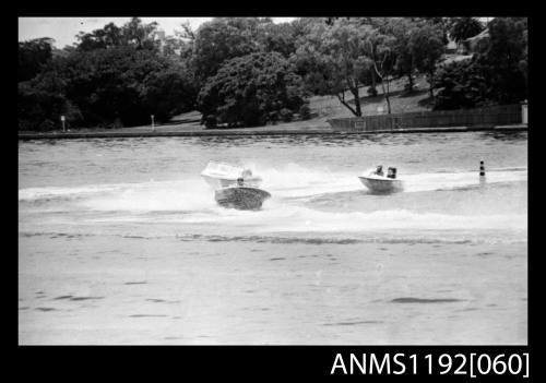 Black and white negative number 19 depicting two power boats with outboard engines under way