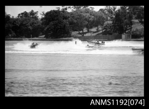 Black and white negative number 31A depicting three open power boats, outboard engines near shore spray