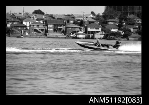 Black and white negative number 7 depicting image open power boat Kathy , outboard engine at speed