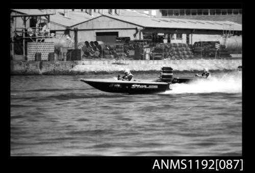 Black and white negative number 11 depicting open power boat STAR Jo4on outboard engine at speed