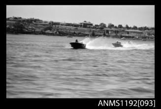 Black and white negative number 17 depicting two open power boats at speed