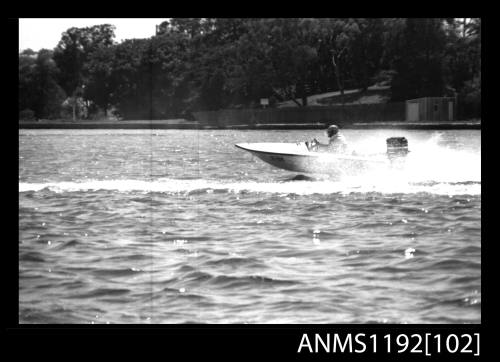 Black and white negative number 3A depicting racing power boat with outboard engine at high speed