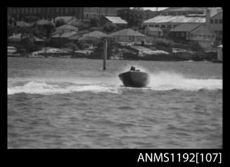 Black and white negative number 8A depicting racing power boat with outboard engine at high speed