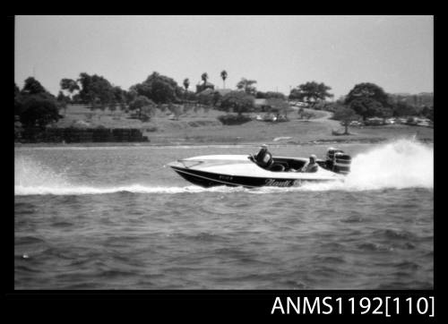 Black and white negative number 11A depicting NAUTI LASS , Kt1twon Racing power boat with outboard engine at speed