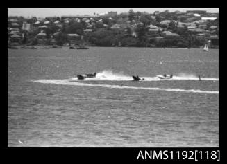 Black and white negative number 19A depicting three racing power boats with outboard engines at turning marker