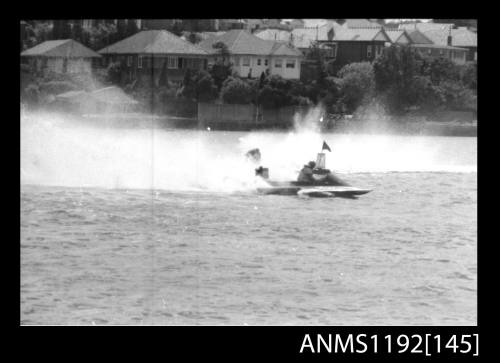 Black and white negative number 9 depicting power boat at speed passing marker buoy