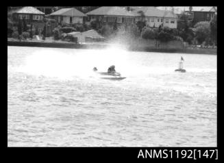 Black and white negative number 11 depicting power boat completing a turn at marker buoy